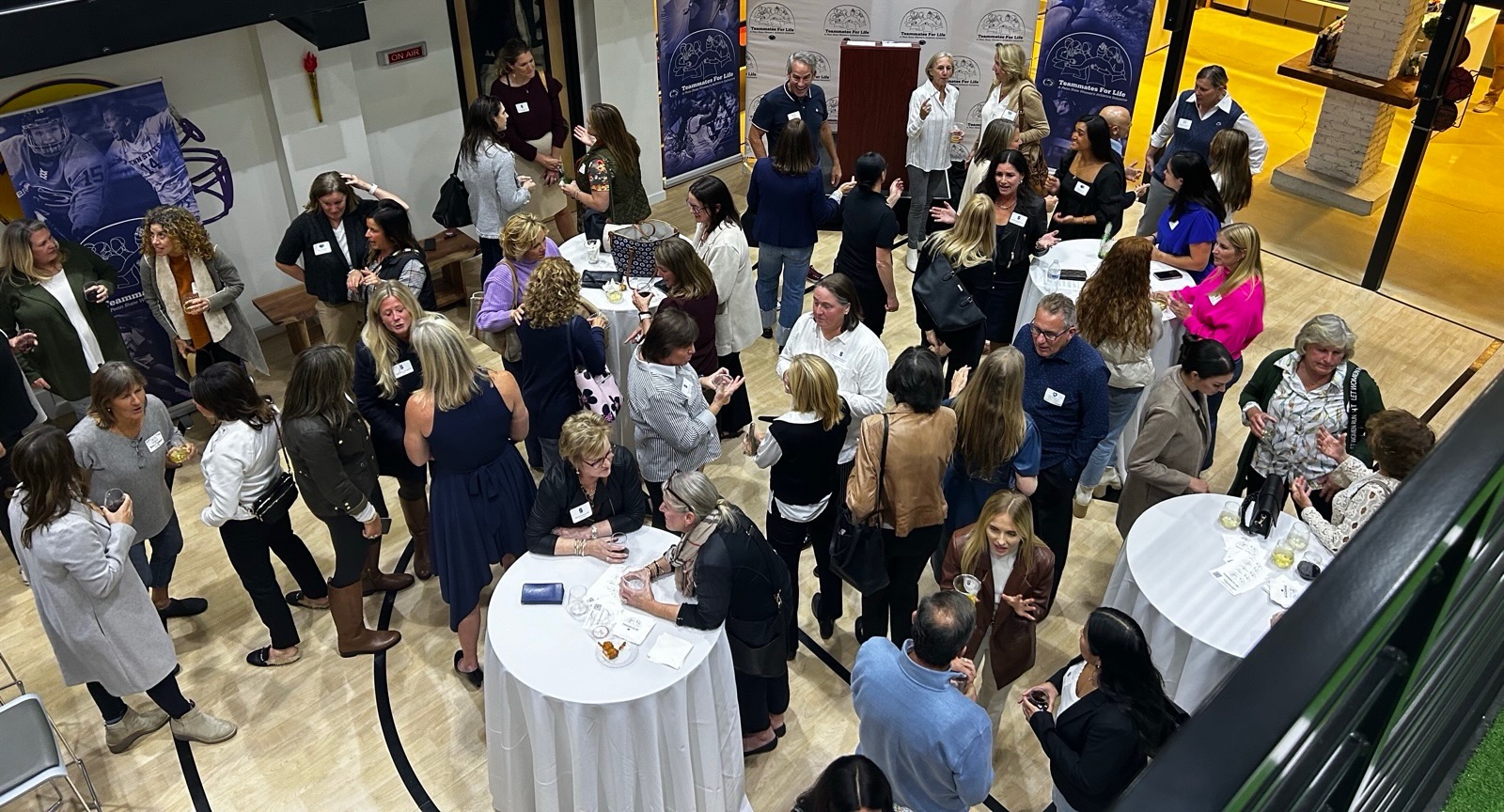 The same room filled with alumnae and student-athletes mingling at the event