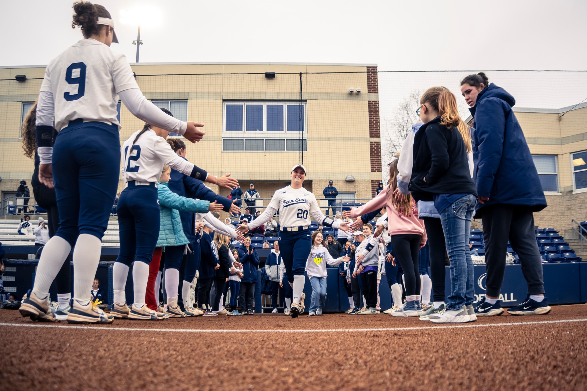 Penn State softball team rotating through high fives from each other